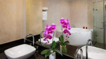 A modern bathroom with two sinks, a bathtub, and a shower.