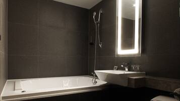 A modern bathroom with a bathtub, a sink, and a toilet.