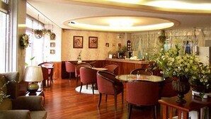 A dining area with a round table, several chairs, and a bar counter. - Asia Tourist Hotel (Pyeongtaek)