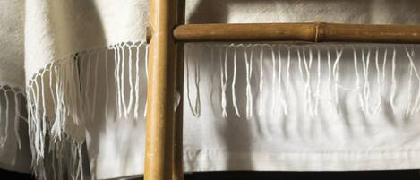 Una silla de bambú con asiento y respaldo tejidos, atados con cuerda.