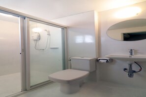 A modern bathroom with a glass shower enclosure, a toilet, and a sink with a mirror above it. - OYO 493 Mali’s Room (Chiang Mai)