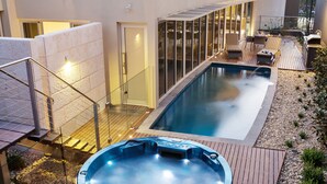 A rooftop pool area with a hot tub, outdoor seating, and a view of the cityscape. - The Frames (Paringa)