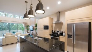 A modern kitchen with a central island, stainless steel appliances, and pendant lighting. - Magic Village Yards, Trademark Collection by Wyndham (Kissimmee)