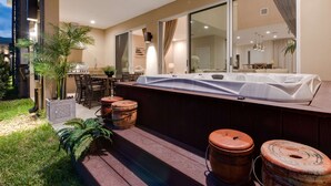 A modern outdoor bar area with a wooden deck, a hot tub, and rustic barrels. - Magic Village Yards, Trademark Collection by Wyndham (Kissimmee)