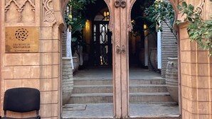 Una entrada ornamentada con dos puertas de madera y un cartel que indica 'Les Bains de Marrakech'.