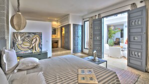 Un dormitorio amplio con una cama grande, un cuadro y vistas al comedor.