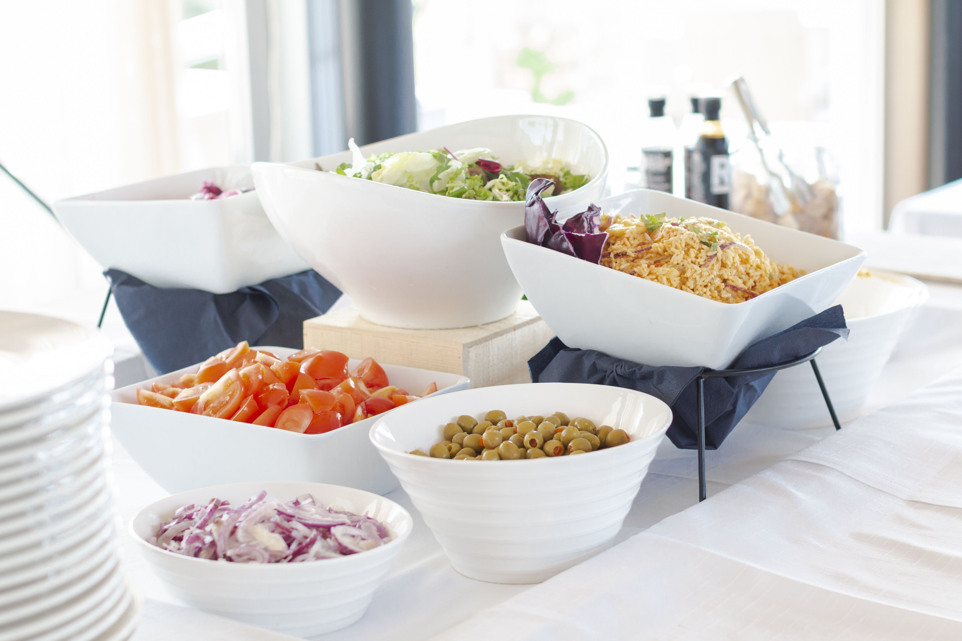 A buffet table with various dishes including a salad, rice, and vegetables.