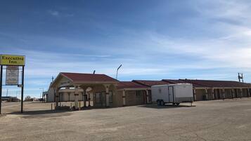 A motel with a sign indicating vacancies and amenities like new clean rooms, breakfast, free cable TV, high-speed internet, and a refrigerator.