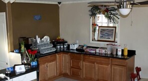 A kitchen with wooden cabinets, a black countertop, and various kitchen appliances.