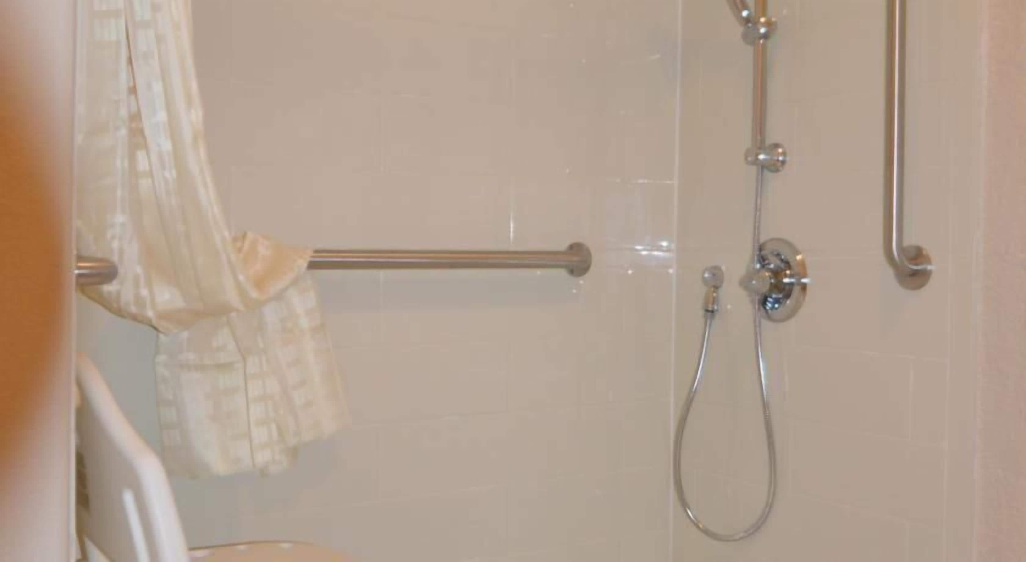 Une salle de bain avec une douche, un porte-serviettes et des toilettes.
