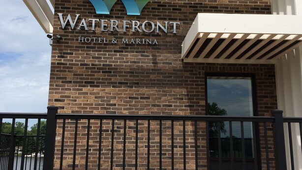 A hotel entrance with a brick facade and a sign reading "Waterfront Hotel & Marina". - Waterfront Hotel and Marina (McHenry)