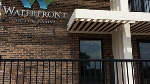 A hotel named 'Waterfront' with a modern design, featuring a brick facade and a balcony with a railing. - Waterfront Hotel and Marina (McHenry)