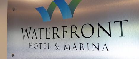 Señal para el Hotel & Marina Waterfront con un logotipo estilizado de 'W'.