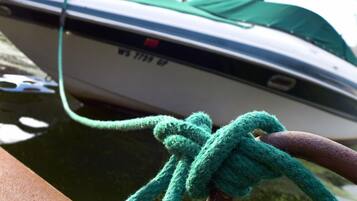 A boat tied to a dock with a green rope.