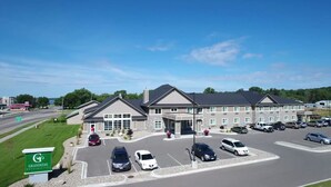 A GrandStay Hotel & Suites with a parking lot, multiple buildings, and a clear blue sky. - GrandStay Hotel & Suites (Glenwood)