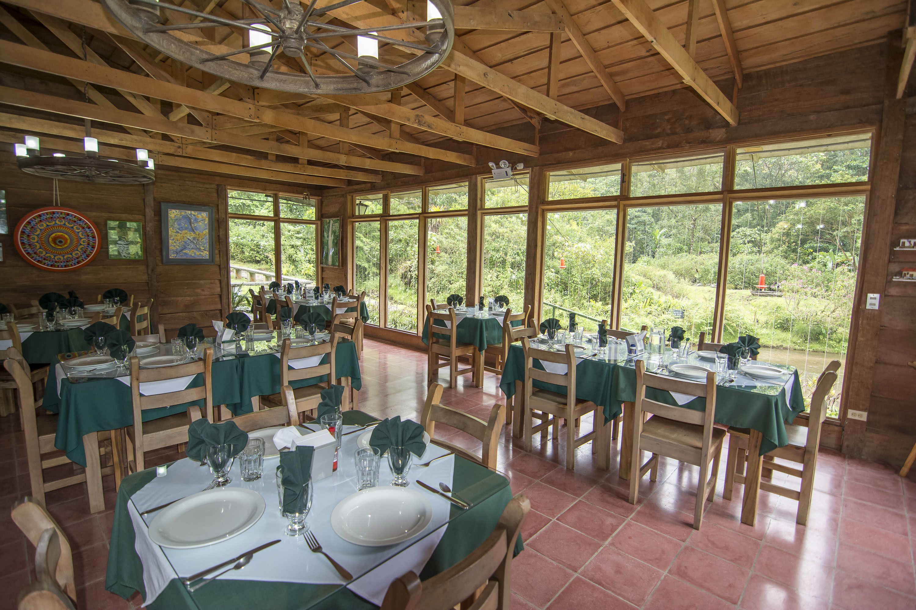Un ristorante con interni in legno, ampie finestre e tavoli apparecchiati per la cena.