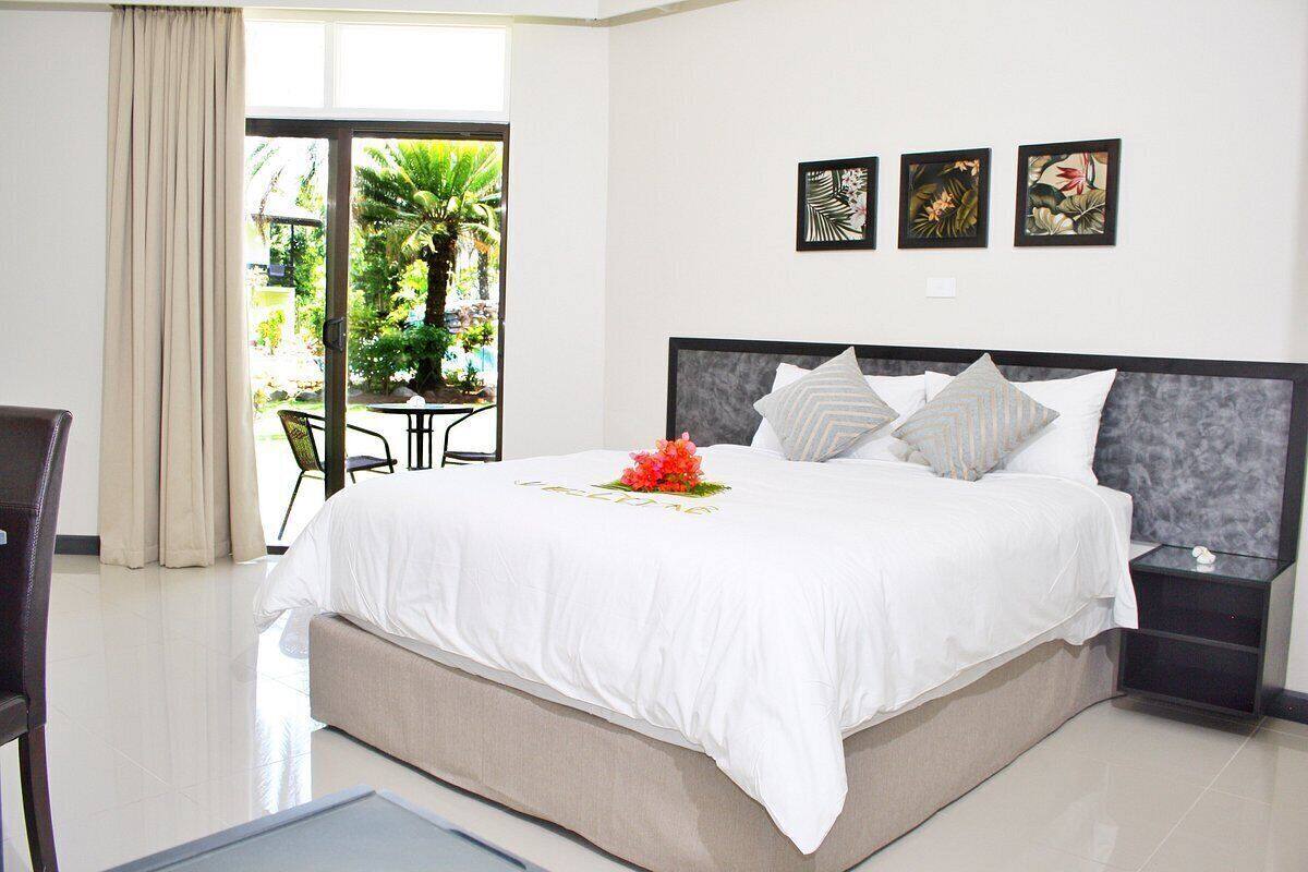 Une chambre d’hôtel avec un lit, une table de chevet, une chaise et une vue sur un jardin.