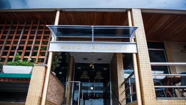 De ingang van HOTEL DO LARGO, met een duidelijk bord boven de deur, een trap die omhoog leidt en een betegelde gevel.