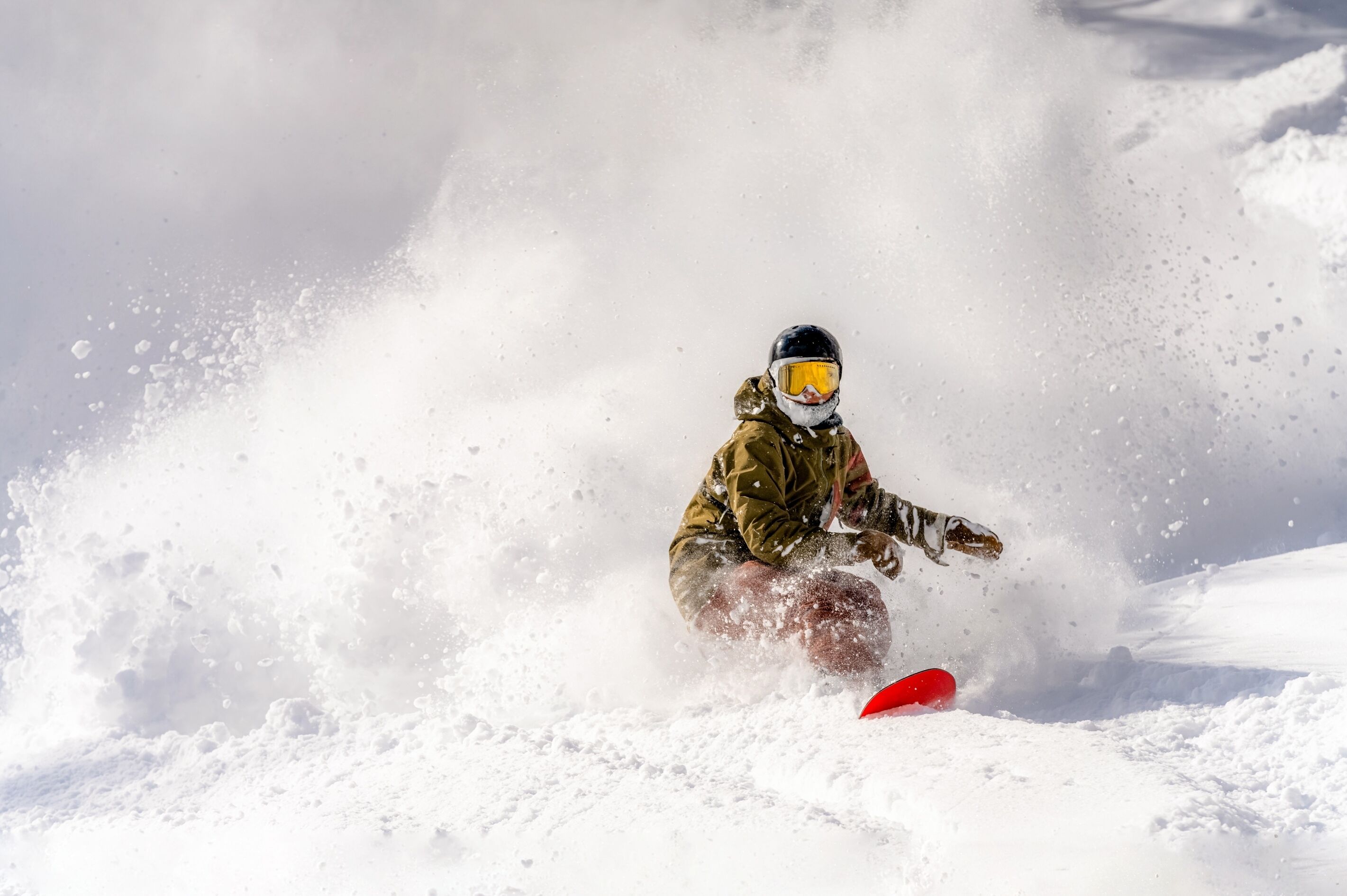 Um snowboarder em movimento, rodeado por neve.