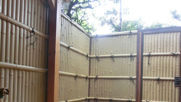 Een traditioneel Japans onsen met een houten structuur en bamboe wanden.