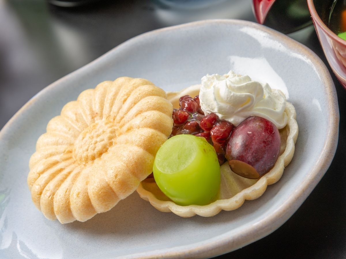 A dessert plate with a pastry, whipped cream, and fruit.