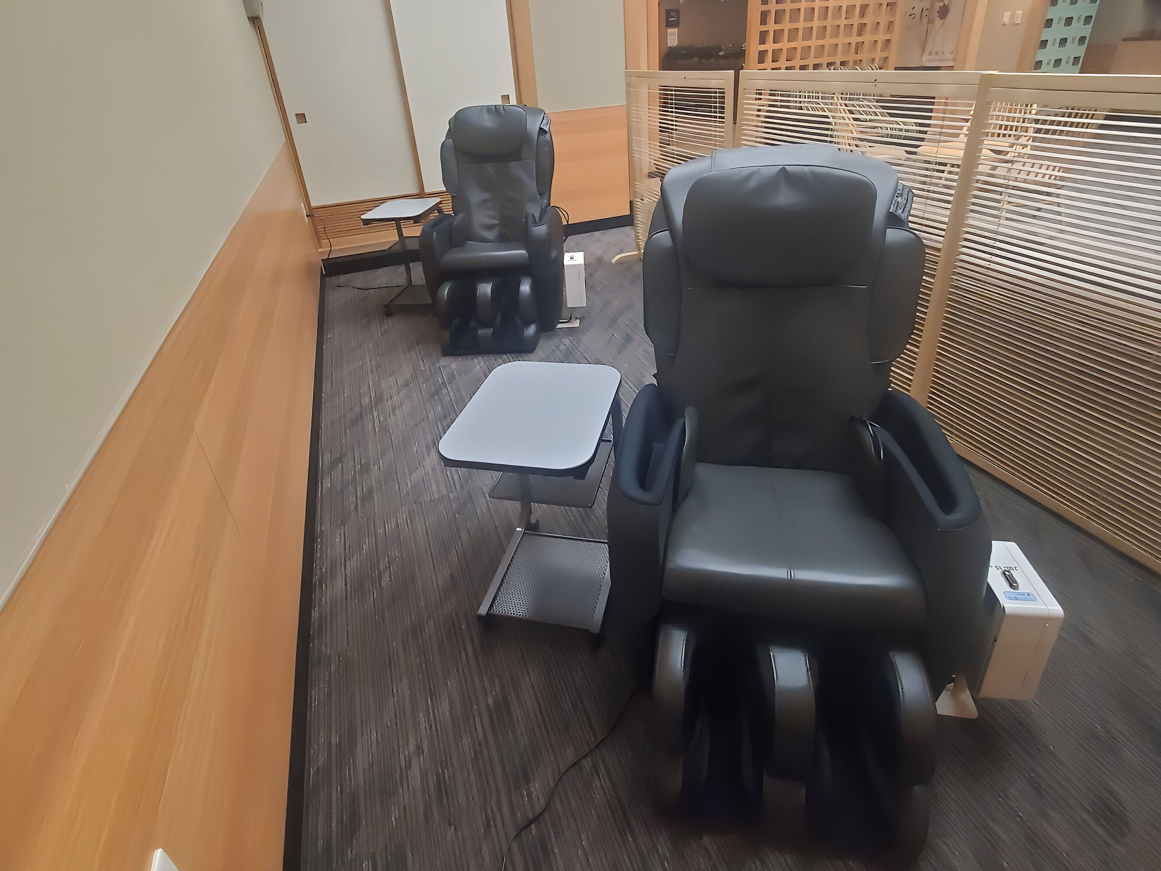 Een massageruimte met twee massagestoelen en een kleine tafel.