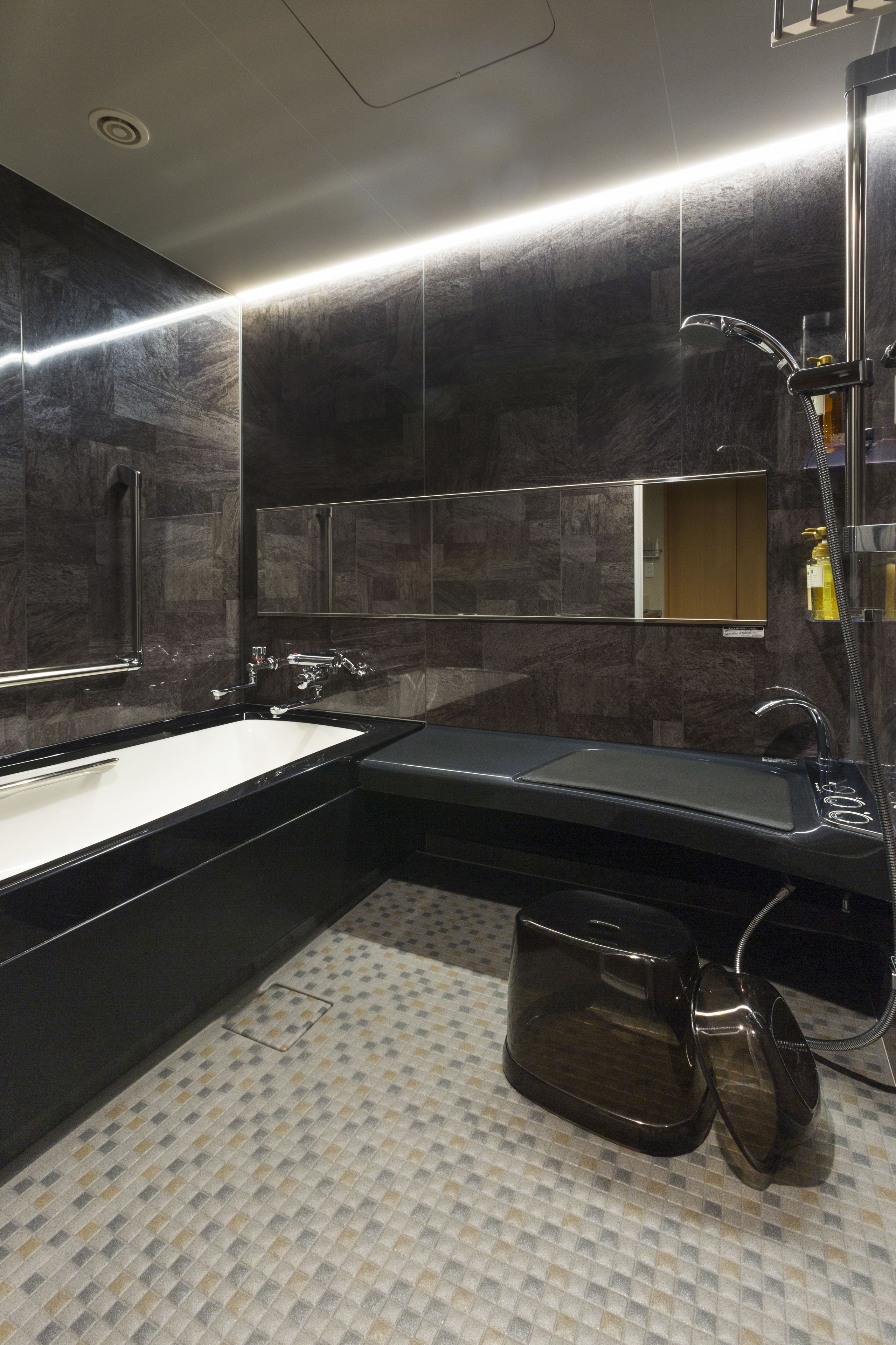 A modern bathroom with a large bathtub, a separate sink, and a shower area.