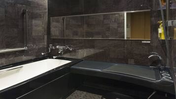 A modern bathroom with a large bathtub, a separate sink, and a shower area.