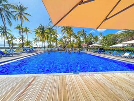 Una piscina al aire libre, sombrillas, tumbonas