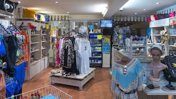 A boutique store with various clothing items, accessories, and a mannequin.