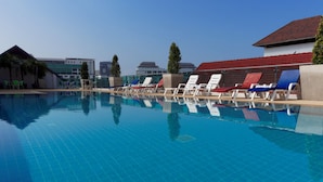 A swimming pool with tiled floors and lounge chairs. - Pattaya Blue Sky (Pattaya)