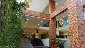 A modern building with a staircase leading to a second floor, surrounded by potted plants and featuring colorful patterned columns. - Pattaya Blue Sky (Pattaya)