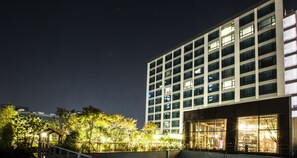 A modern building with multiple floors, large windows, and a well-lit entrance.