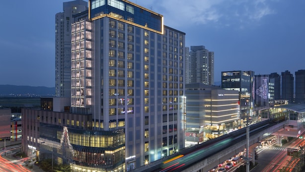 A high-rise hotel with multiple floors, large windows, and a modern architectural design. - Isquare Hotel (Gimhae)