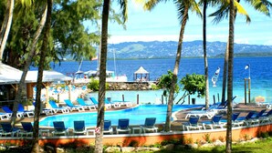 A pool area with lounge chairs and a view of the sea. - Résidence La Marina (Trois-Ilets)