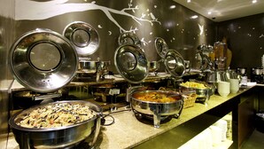 A buffet setup with multiple serving stations, including large bowls and containers for food. - Rich Diamond Hotel (Seoul)