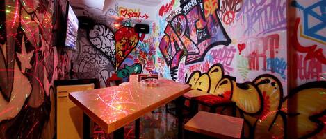 Een kamer met muren en tafels vol graffiti, met een mix van kleurrijke en abstracte ontwerpen.