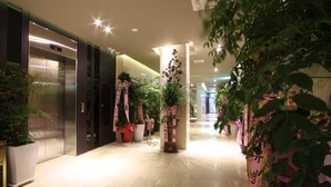 A hotel corridor with a modern elevator, potted plants, and a clean, well-lit interior. - Rich Diamond Hotel (Seoul)