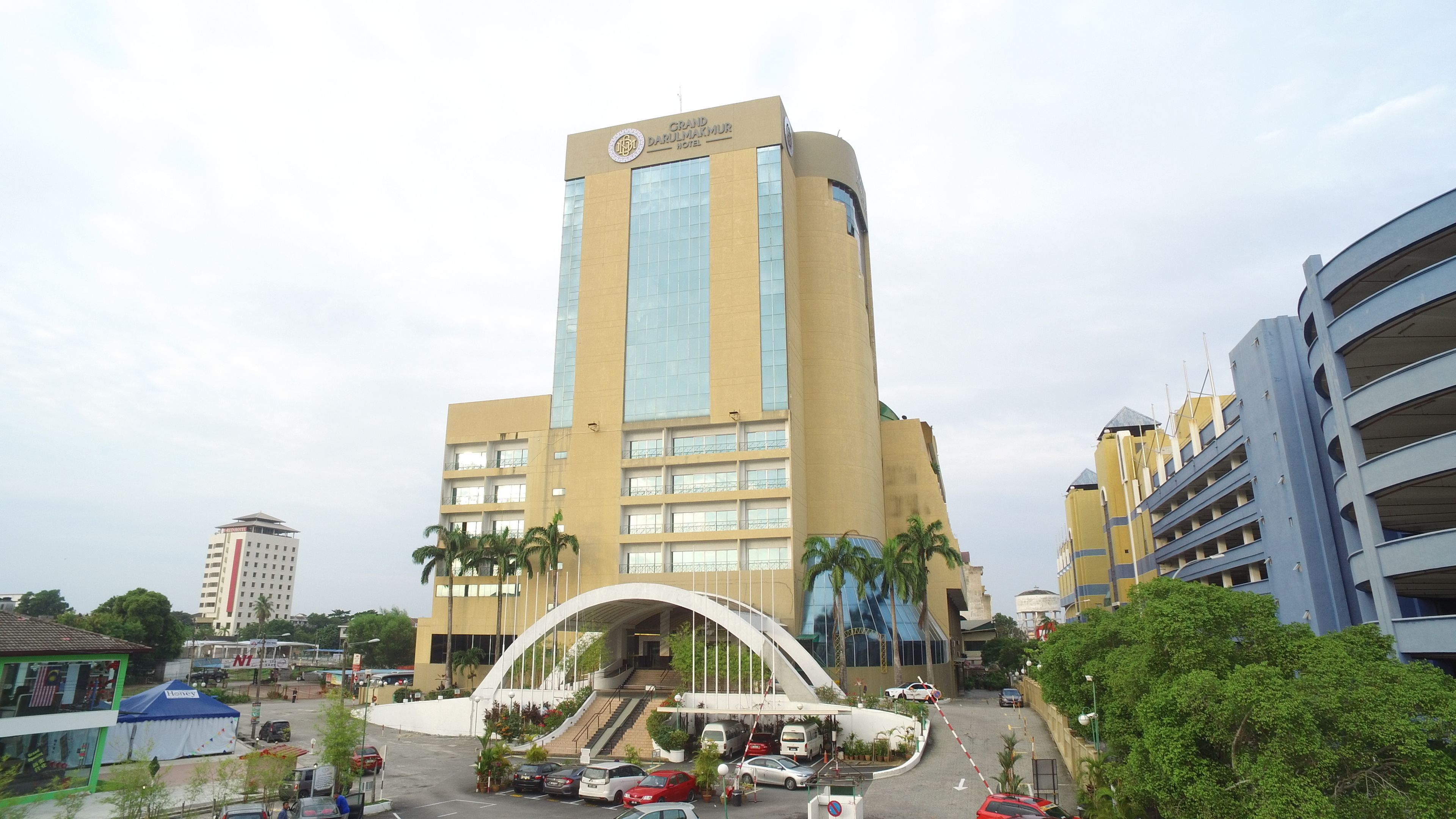 A hotel with a modern design, featuring a prominent curved entrance and multiple floors.