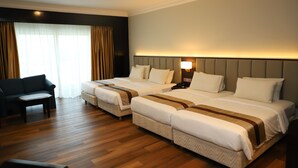 Een hotelkamer met twee bedden, een slaapbank en een bureau.