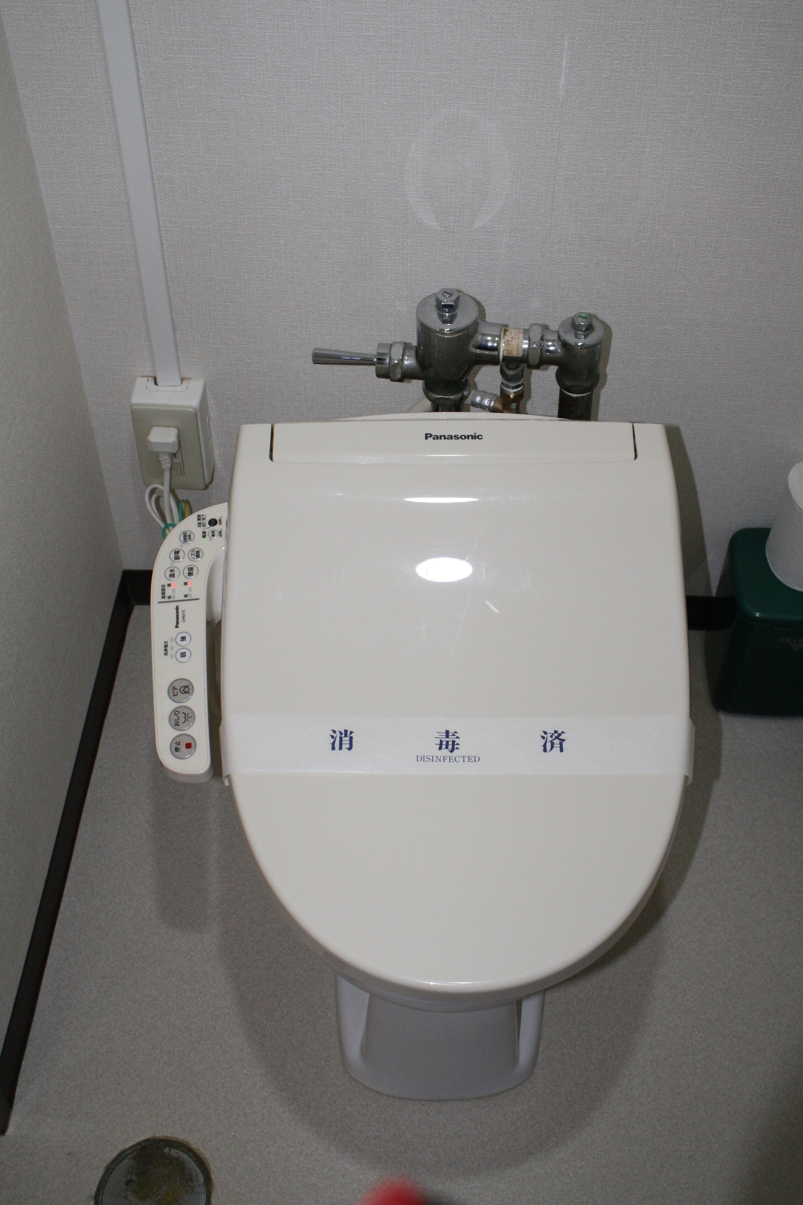 A white toilet with a control panel and a foot pedal.