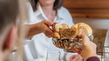 Iemand serveert brood aan een ander persoon aan tafel.