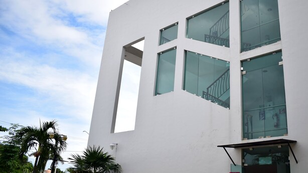 A modern building with large windows and a visible staircase. - Hotel Principe (Chetumal)