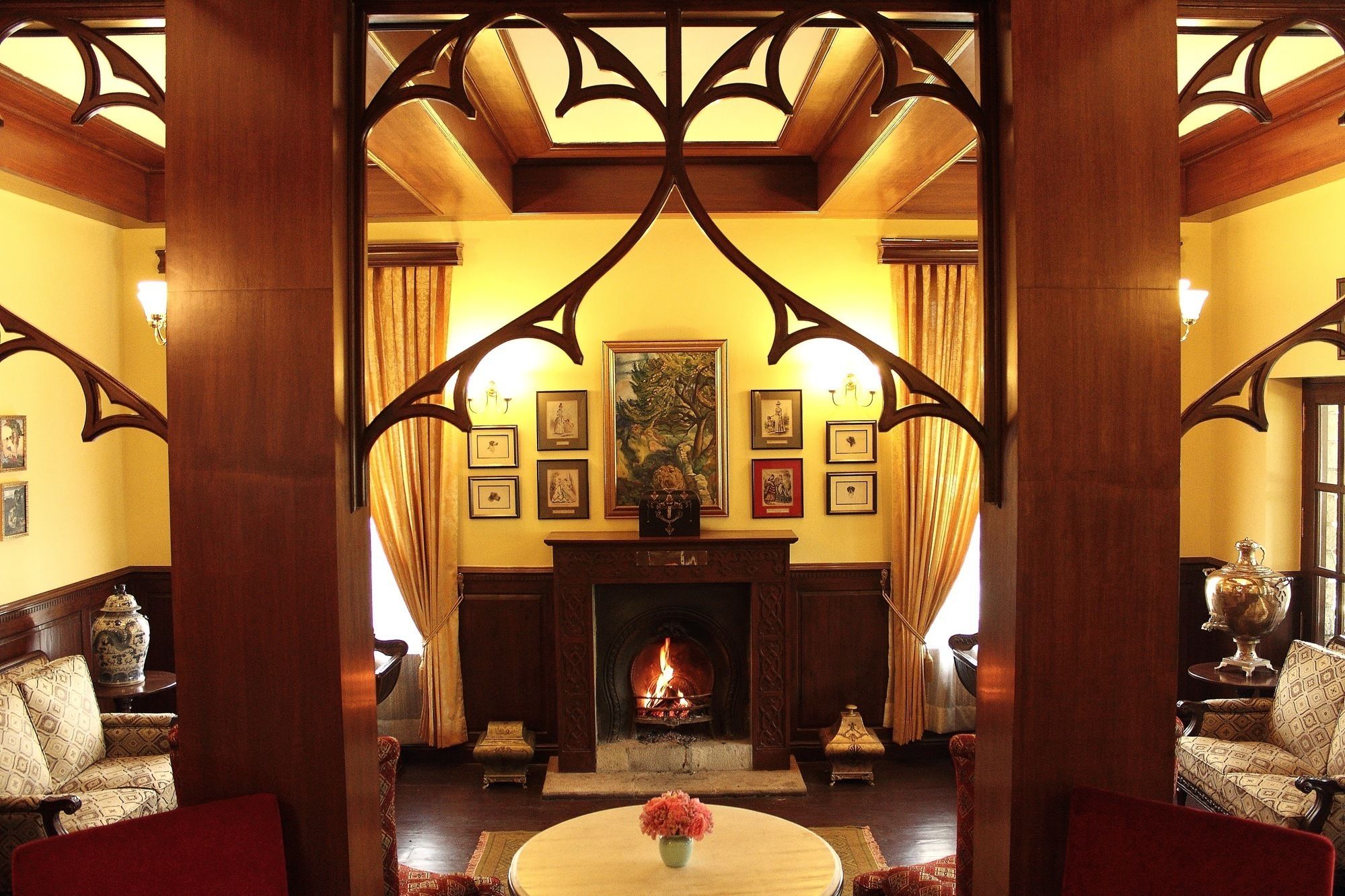 Un amplio vestíbulo con chimenea, obras de arte enmarcadas y muebles tradicionales.