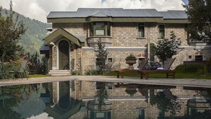 A stone building with a reflective pool in front.