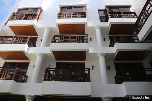 A multi-story building with balconies, columns, and a clean facade.
