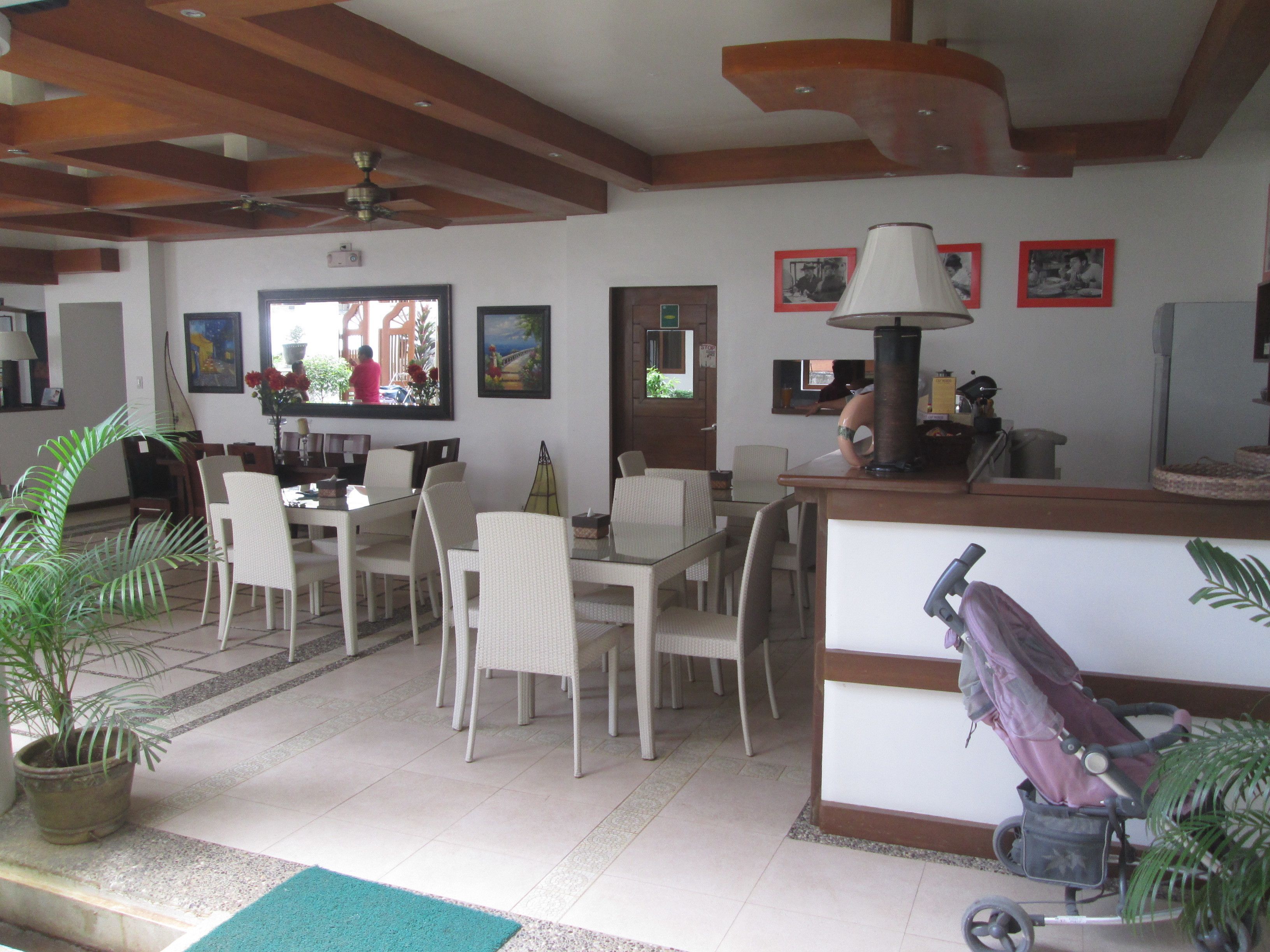 A dining area with a table and chairs, a ceiling fan, and a potted plant.