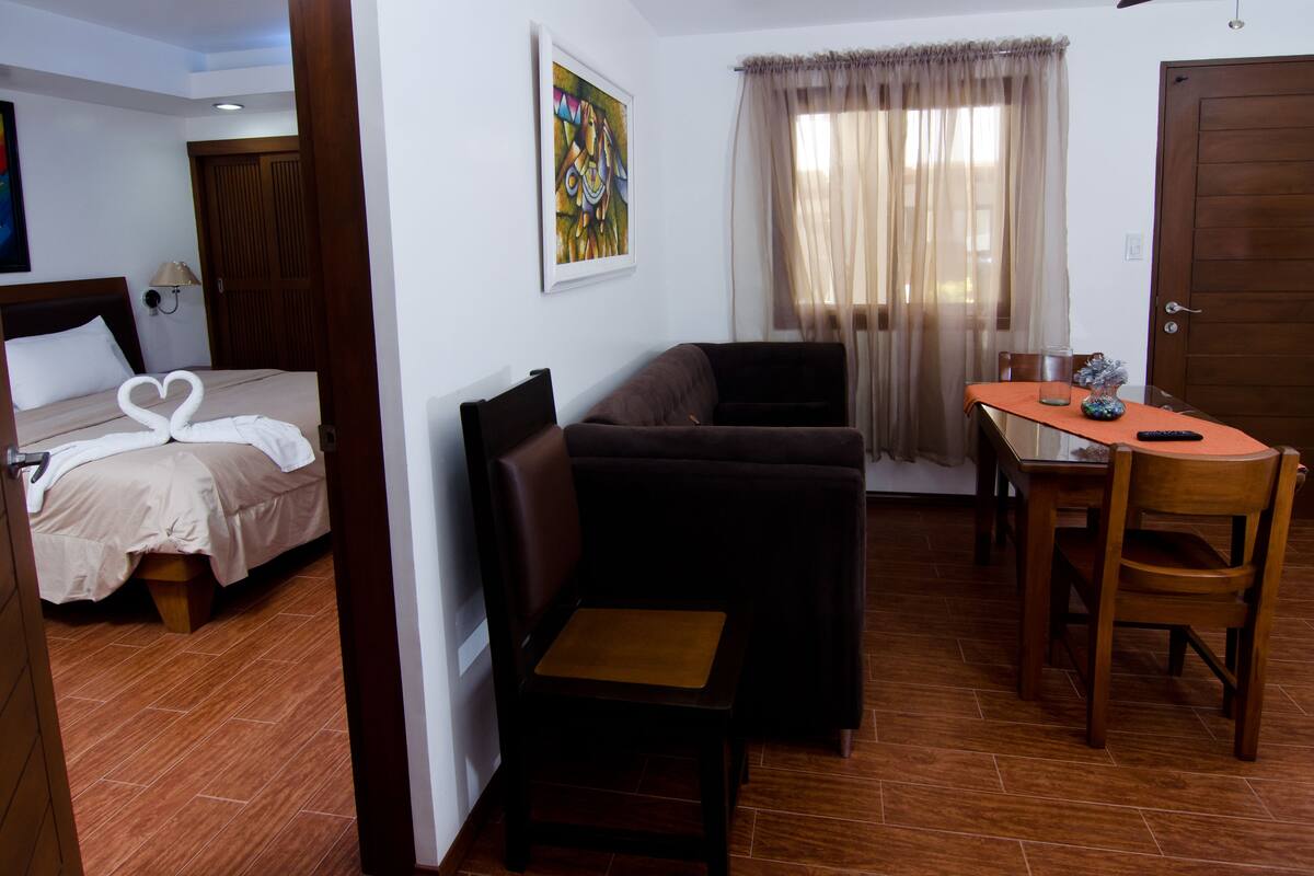 Une chambre d’hôtel avec un lit, un canapé, une petite table et une chaise.