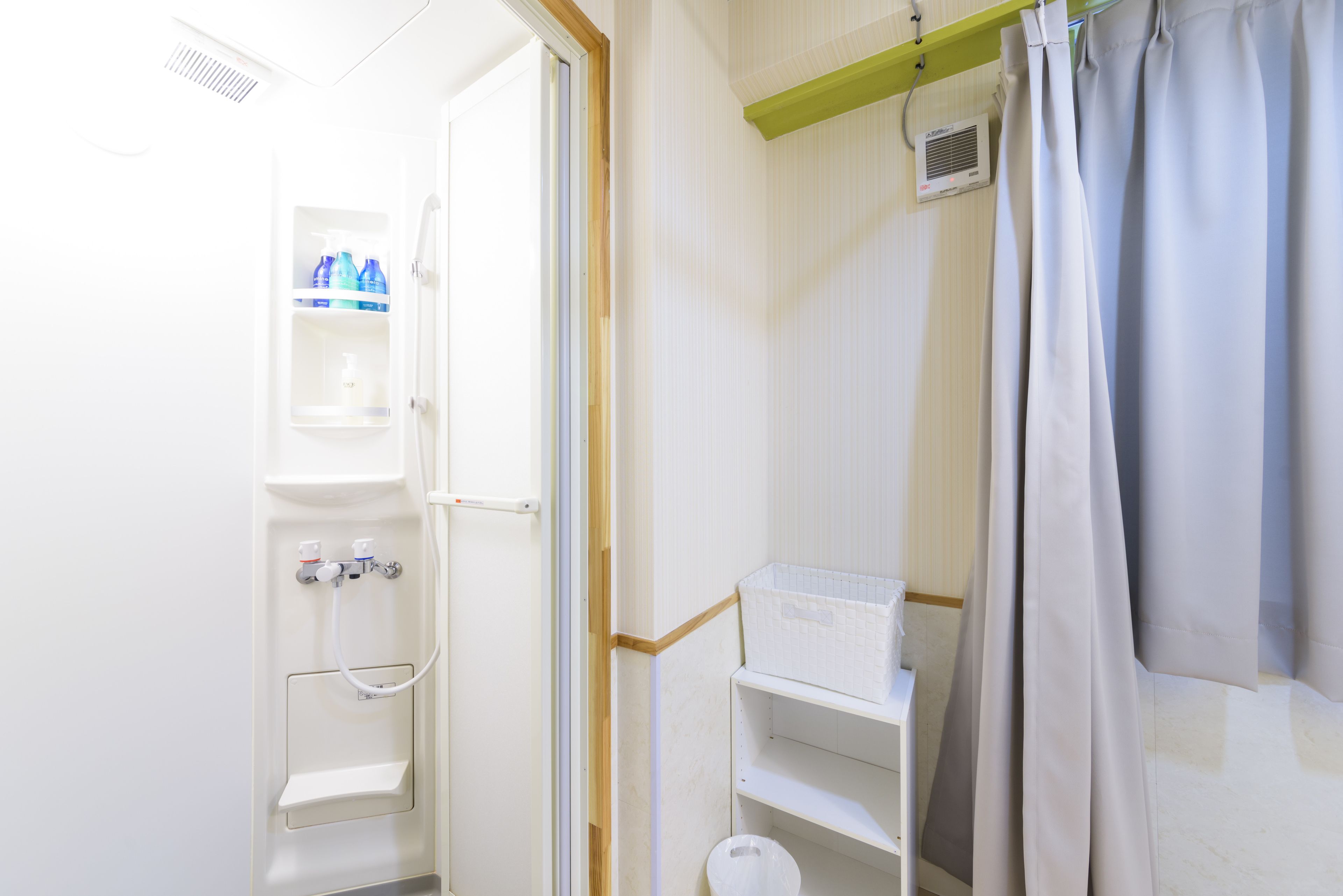 Une salle de bain équipée d’une douche, de toilettes et d’étagères de rangement.