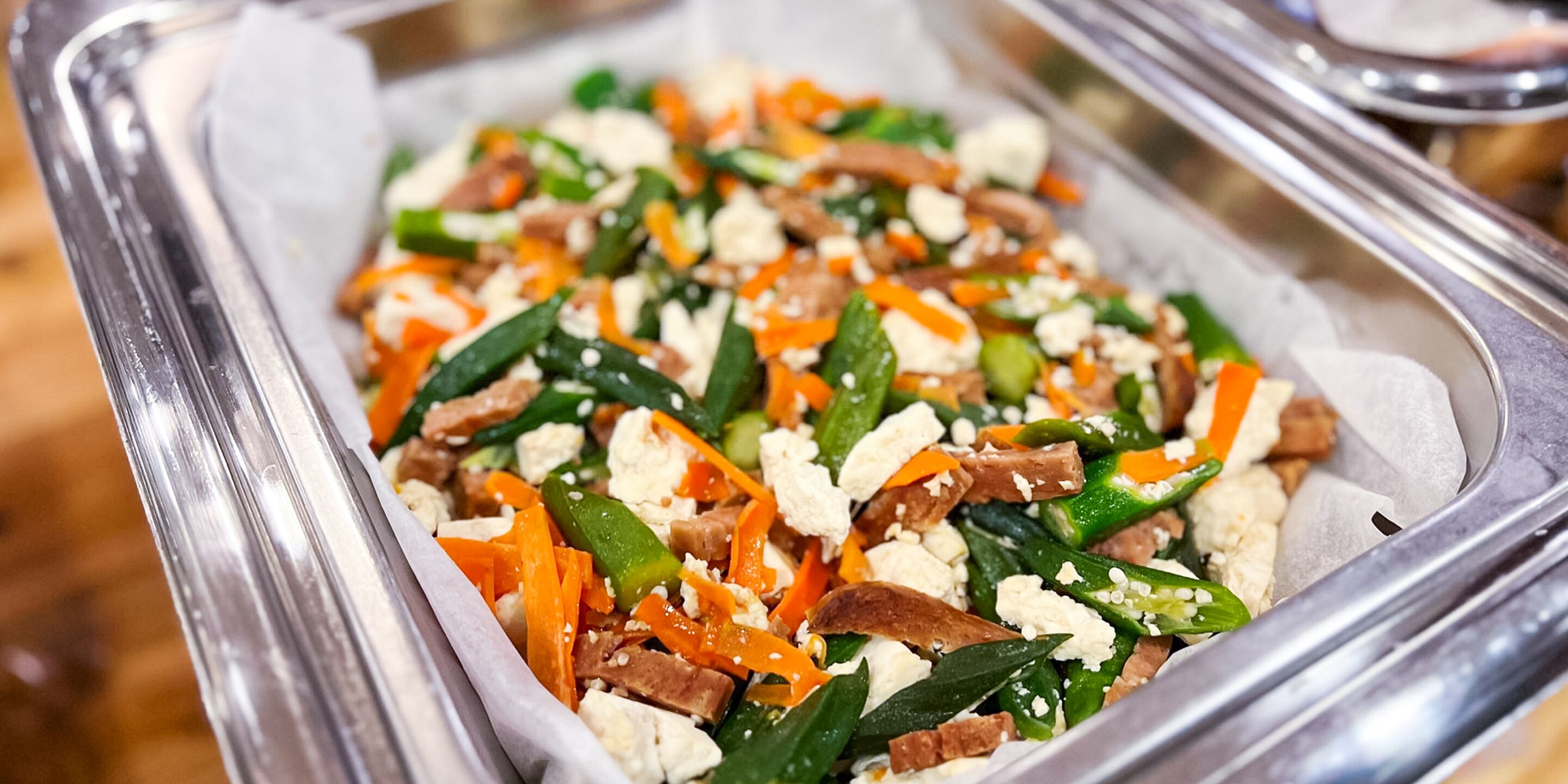 A tray of food with various vegetables and cheese.